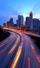 Fototapeta premium A panoramic view of a cityscape at dusk with a highway leading into the city. The city is illuminated by the setting sun, and the highway is filled with cars.