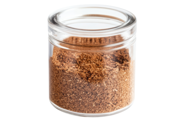Clear glass jar filled with ground brown spice, isolated on white background. Ideal for cooking ingredients and seasoning.