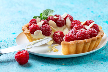 Sliced tartlet with custard and raspberries.