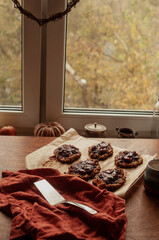 Home made seasonal plum pies or tarts with oatmeal crust aesthetic seasonal  moodyy lifestyle autumn usg shot with pumpkin decoration back light