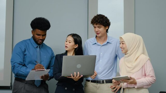 Group of happy multicultural architect business team people Standing in a meeting using a laptop, tablet and files to check work, working towards their shared goals, talking and smile