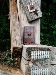 The ancient railway piers and large beams made of wood support an old rundown train bridge and were constructed during World War II.  View of old wooden bridge of train railway along cliffs and rivers