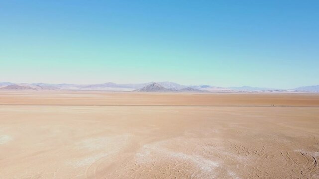 Drone back across Nevada dry lake bed on a sunny summer day