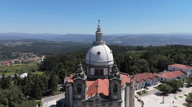 Drone view of the Sanctuary of Sameiro's dome with surrounding forest and distant mountains