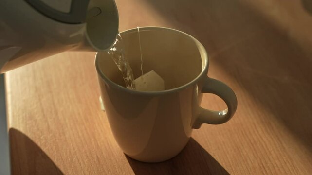 Making a cup of tea in the kitchen, on a wooden counter with morning golden light