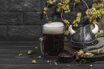 Creative Oktoberfest composition. Dark beer, viking helmet, hop and wheat. German festival concept