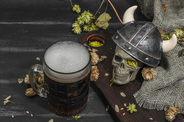 Creative Oktoberfest composition. Dark beer, viking helmet, hop and wheat. German festival concept