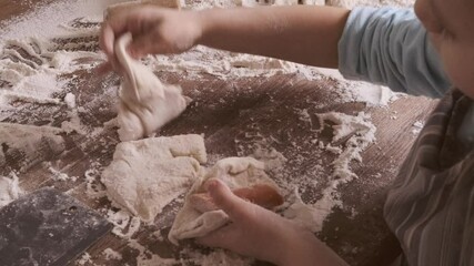 Little 5-year-old girl kneads dough in kitchen, mastering cooking skills, flour on countertop, joyful childhood, family teamwork and teaching children responsibility from young age