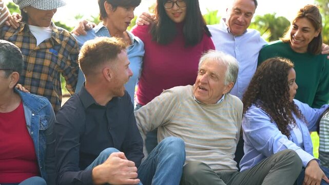 Crowd of multiracial people having fun hugging each others at city park - Social inclusion, collective and multi generational community concept