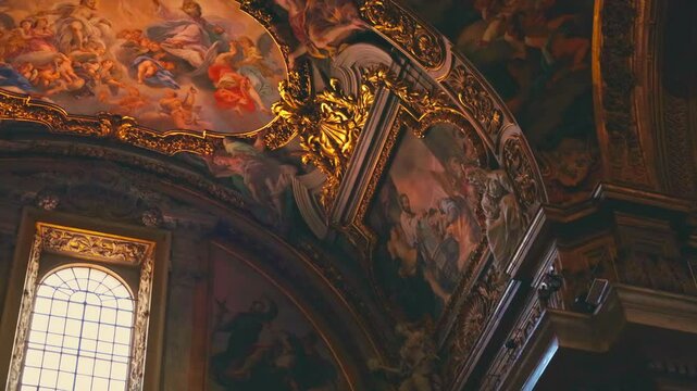 Marvel at the intricate artwork and golden embellishments adorning the vaulted ceilings above in the Church of the Gesu
