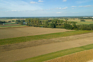 Fototapeta premium Aerial view of beautiful rural fields in vibrant colors under a clear sky