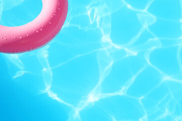 Pink inflatable ring in swimming pool outdoors