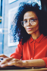 Portrait of attractive afro american copywriter working remotely with modern netbook in cafe...