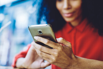 Selective focus on female hands holding modern smartphone gadget and enjoying communication on website for meeting new people connected to 4g wireless for browsing internet, blurred background
