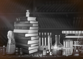 Chemist's workplace with old books and laboratory glassware, vintage style