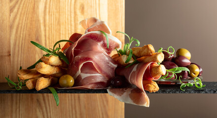 Prosciutto with bread sticks, olives, and rosemary.
