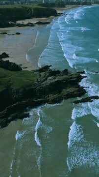 Vertical video of the waves on the beach  at Mawgan Porth Beach in