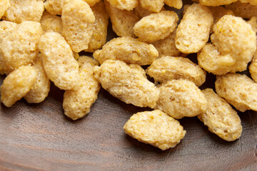 Processed dry oat flakes in wooden kitchen bowl. Organic nutritional uncooked ingredient of healthy cereal breakfast food. Macro. 