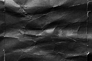 Black paper background with wrinkles, folds and crumpled distressed surface. Abstract grunge poster