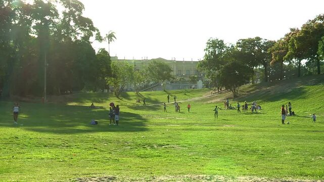 Lively park scene at Quinta da Boa Vista with people enjoying outdoor activities on a sunny day.  Pal&aacute;cio Nacional Museu