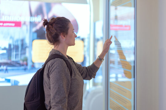 Woman uses self-service desk with touch screen