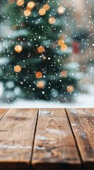 Festive Christmas scene with blurred tree and twinkling lights in background, wooden table in foreground, falling snow creating magical atmosphere.