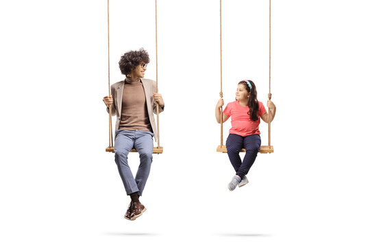 Young man and a little girl sitting on swings