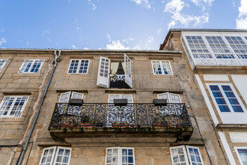 Elegant European balcony with iron railings and open shutters on historic stone facade