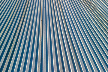 Fototapeta premium Close-up view of a textured metal surface showing parallel lines and shadows, conveying industrial aesthetics and modern design