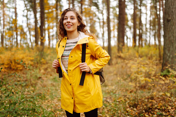 Happy woman having fun and enjoy the autumn weather in the forest. Calmness and tranquility. Travel, tourism concept.