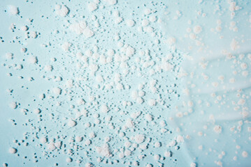 Cosmetic products on a blue background. Sample of enzyme powder and clear liquid cosmetics. Texture of cosmetic skin care product