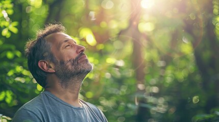 Fototapeta premium A man is looking up at the sky in a forest