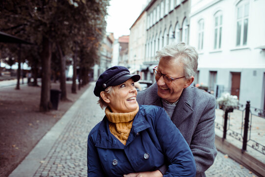 Elderly couple sharing a joyful moment on a city walk
