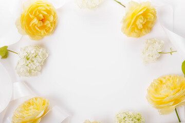 Festive frame of yellow roses and white hydrangeas with white ribbon. Congratulatory wedding autumn background