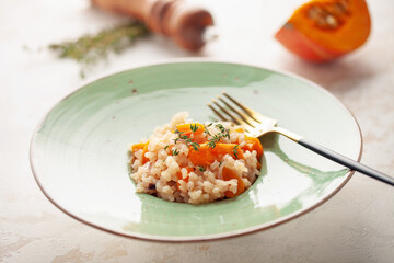 Pumpkin risotto with fresh thyme in plate. Italian Food