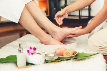 Man indulges in blissful foot massage at luxurious spa salon while masseur give reflexology therapy in gentle day light ambiance resort or hotel foot spa. Quiescent