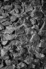 Wet grey embossed stone wall for abstract background and texture for interior or exterior design. Beautiful patterns, space for work, banner, wallpaper close up.Vertical.