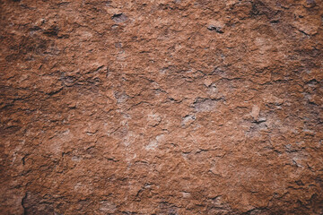 Brown rough stone wall for abstract background and texture for interior or exterior design. Beautiful patterns, space for work, banner, wallpaper close up.