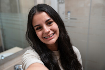 brunette teenager with braces taking a selfie