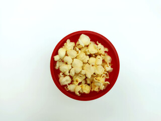 Popcorn in a red bowl  on the white background with copy space.
