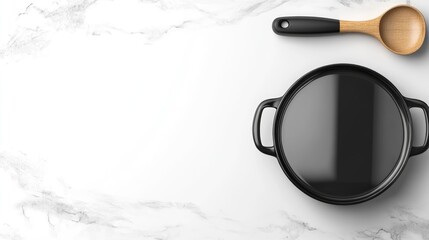A cooking pot rests on a sleek black hob amidst natural light, showcasing a stylish modern kitchen counter adorned with wooden utensils for culinary creativity