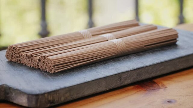 Buckwheat soba pasta on a black texture background.Raw thai noodles and Ingredients for a gluten free dish. Dried buckwheat soba noodles. Traditional Japanese food. Healthy food.