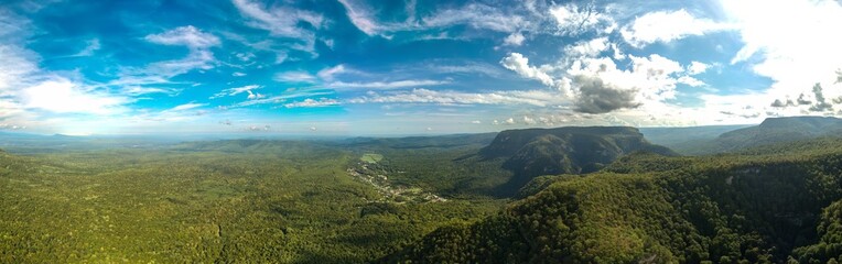 Obraz premium large aerial view panorama of the surroundings of the village Guamka, surrounded by green forest (western Caucasus, Russia) on a sunny summer day