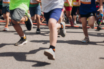 Children marathon runners crowd, young teen sportsmen participants start running in the city streets, crowd of kids joggers in motion, kid group athletes outdoor run, family competition in summer day
