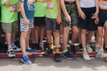 Children marathon runners crowd, young teen sportsmen participants start running in the city streets, crowd of kids joggers in motion, kid group athletes outdoor run, family competition in summer day