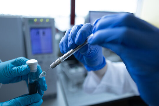 Scientist injecting a sample via the autosampler of HPLC system. High performance liquid chromatography at chemical laboratory. Developing of pharmaceuticals or vaccine. Biochemistry analysis