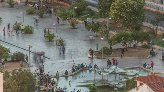 Aerial view of Martim Moniz Square timelapse in Lisbon, Portugal. People sitting and walking near fountain. A bustling hub of culture and diversity, framed by historic architecture during sunset