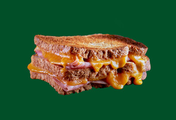 Ham and cheese toasted sandwich on a green background.