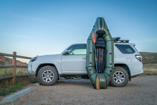 Fort Collins, CO, USA - October 1, 2024: Alpacka Ranger packraft with Aqua Bound paddle against Toyota 4Runner SUV at dusk in Lory State Park.