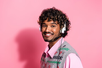 Portrait of nice young man communicate operator headset wear xmas new year vest isolated on pink color background